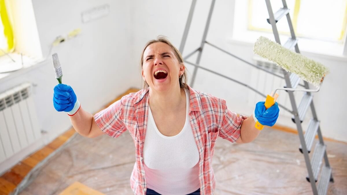 Femme dépassée pendant des travaux de peinture dans son intérieur